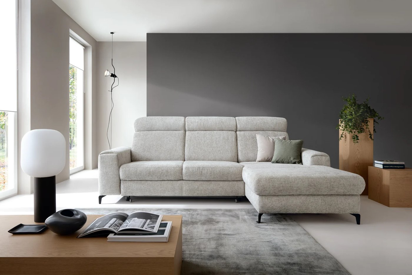 Svetlá rohová sedačka CANES s vysokými operadlami a otomanom v modernom interiéri.