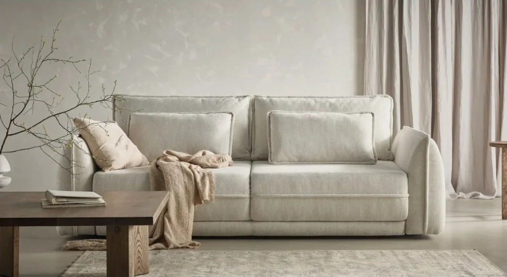 LYNX sofa – celá rozkladacia pohovka v svetlom čalúnení v interiéri.