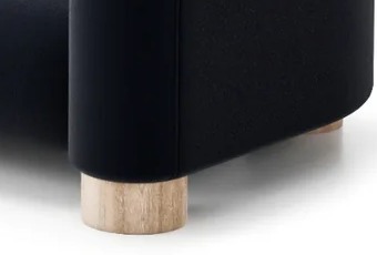 PAVIO sofa S2 – detail valcovitej nohy z masívneho dreva pod oblou podrúčkou.