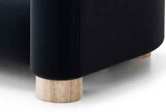 PAVIO sofa S3 – detail valcovitej nohy z masívneho dreva pod oblou podrúčkou.