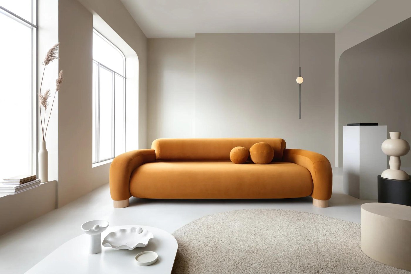 PAVIO sofa S4 – celá štvormiestna pohovka v horčicovom čalúnení pri veľkých oknách v interiéri.