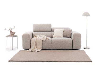 Pohovka RIPLE Sofa 3 v svetlobéžovej poťahovej látke zobrazená spredu v jemnom aranžmáne s kobercom, dekoračnými vankúšmi, prehozom, stolíkom a stojacou lampou.