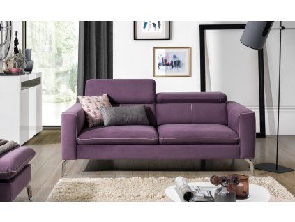 Pohovka LASIA SOFA 2 vo fialovom čalúnení v interiéri, dvojmiestna sedačka s vankúšmi, pohľad z uhla.