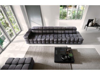 Rovná sedacia súprava DRACO SOFA V9 tmavosivá v modernom interiéri, pohľad zhora na dlhú pohovku s výrazným prešívaním a veľkým presklením.