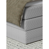 Boxspring posteľ DREAMO, detail rohu rámu, sivého čalúnenia a švov.