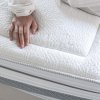 Matrac LUSSA – detail prešívaného poťahu COLLAGEN a bočnej sieťoviny s rukou na povrchu.