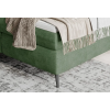 Boxspring posteľ PEAK, detail zeleného čalúneného rohu a sivej nohy.