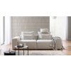 Pohovka LUNA SOFA 1 (1,5BL + 1,5BP) v svetlom krémovom prevedení v obývačke, pohľad spredu so stolíkom, lampou a dekou.
