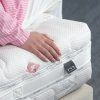 Matrac Swiss Exclusive, ruka položená na prešívanom poťahu pri okraji matraca.