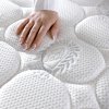 Matrac Monaco Dream, ruka pritláča kruhový prešívaný poťah, detail štruktúry a mäkkosti povrchu.
